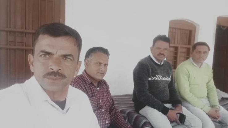 Teachers of Jujpur school telling people the merits of government schools